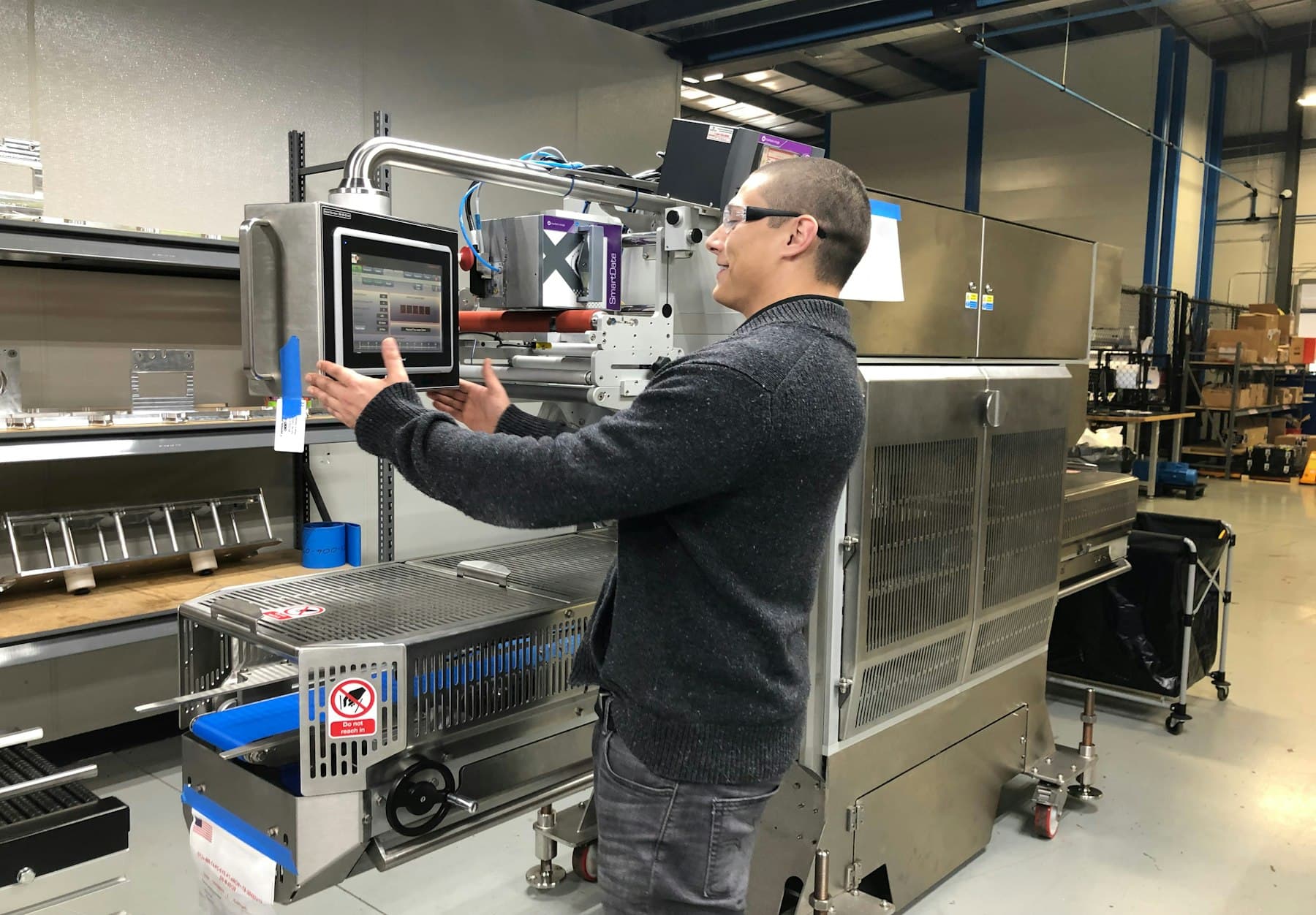 Engineer configuring a machine HMI touchscreen on an automated production line